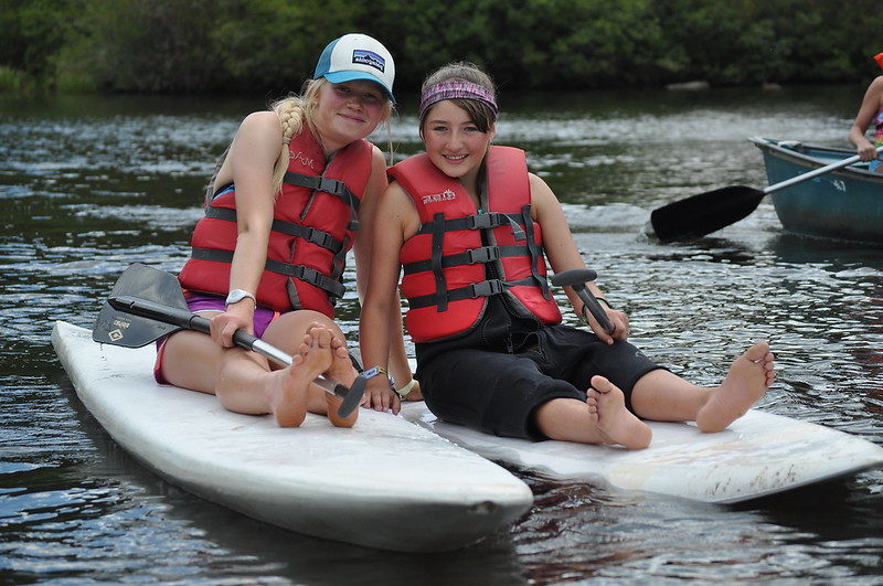 Camp Counselor and camper go paddle boarding and pose for a picture!